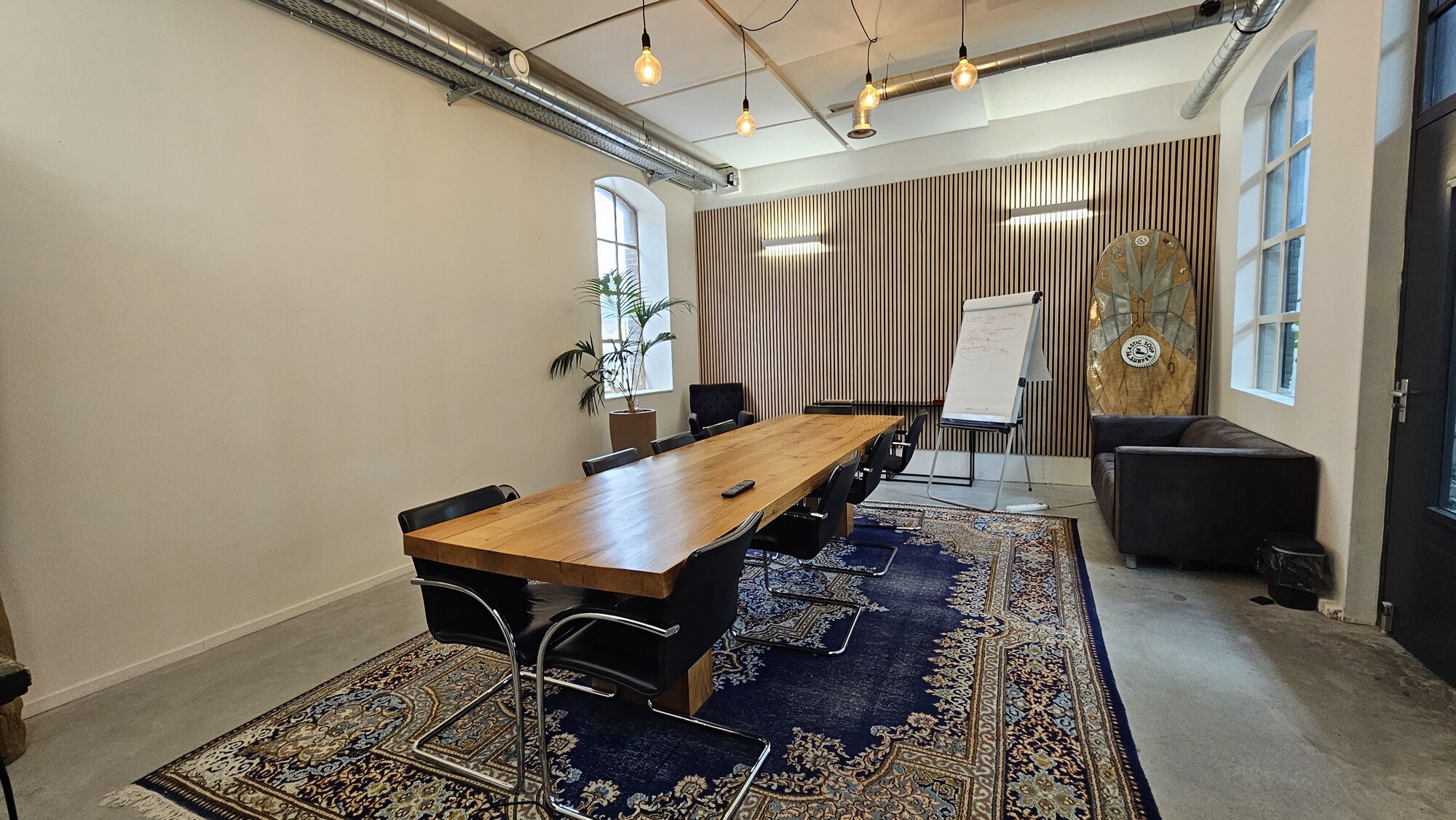 Een kleinere vergaderruimte met een houten tafel